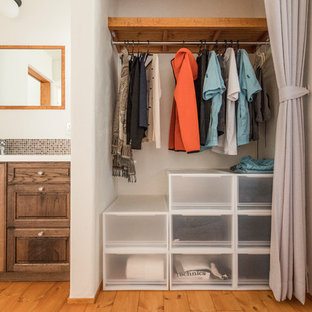 Modelo de armario y vestidor ecléctico con suelo de madera en tonos medios y suelo beige
